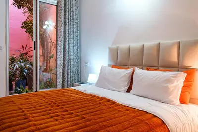 a bedroom with a large bed with an orange blanket at 1Br & private garden perfect location in Marrakech in Marrakech