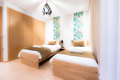 a bedroom with three beds in a room at M REVASION Appt 3 chambres , front de lac , piscine chauffée privée in Marrakech