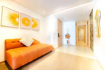 a bedroom with an orange bed and a hallway at M REVASION Appt 3 chambres , front de lac , piscine chauffée privée in Marrakech
