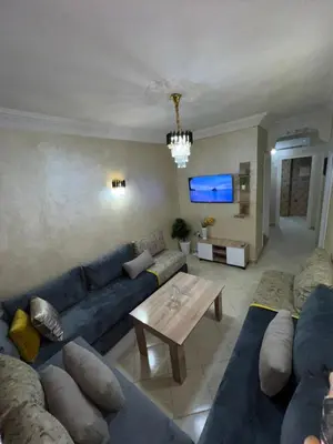 a living room with a blue couch and a table at votre parfait sejour in Marrakech