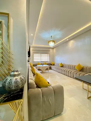 a living room with a couch and a table at Lux appartement avec piscine in Marrakech