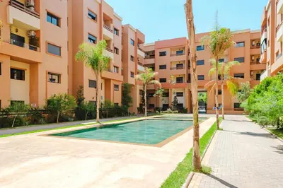 an apartment with a swimming pool in front of a building at Central Marrakech Apart 2 Minutes from M Avenue with Pool & parking & Wifi in Marrakech