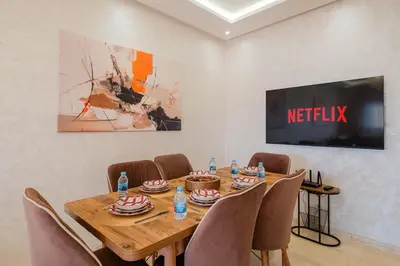 a dining room with a wooden table and chairs at Central Marrakech Apart 2 Minutes from M Avenue with Pool & parking & Wifi in Marrakech