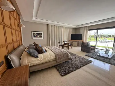 a bedroom with a large bed and a living room at Luxury Villa Pool with Atlas View in Moussiha