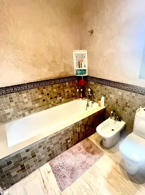 a bathroom with a bath tub and a toilet at Superbe villa 3 chambres proche du centre-ville avec piscine privée in Marrakech