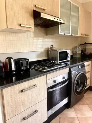 a kitchen with a stove and a microwave at Superbe villa 3 chambres proche du centre-ville avec piscine privée in Marrakech