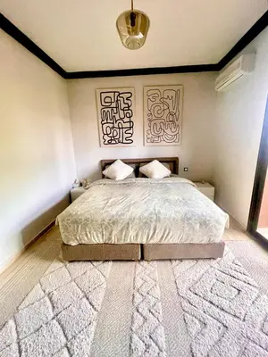 a bedroom with a large bed and a rug at Superbe villa 3 chambres proche du centre-ville avec piscine privée in Marrakech