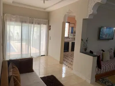 a living room with a couch and a large window at paradis in Aït Bou Setta