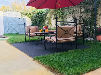 a table and chairs under an umbrella on a lawn at paradis in Aït Bou Setta