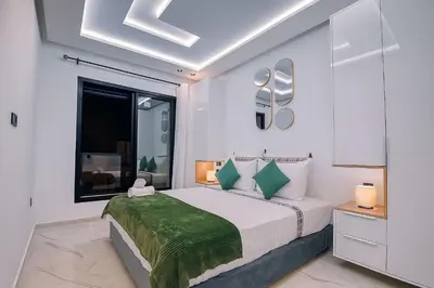 a white bedroom with a bed and a window at Laube Hivernage in Marrakech