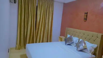 a bedroom with a bed with a yellow curtain at Appartement Majorella Gueliz Centre Marrakech in Marrakech