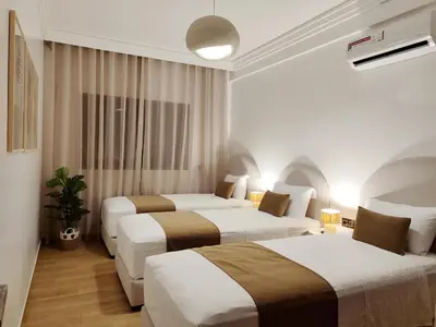 a hotel room with two beds in it at Ochre City apartment Balcony, Pool, Fiber Optic, Free Parking - Family ONLY in Marrakech