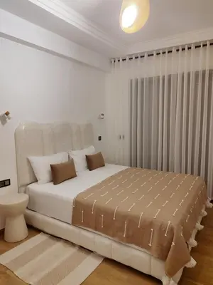 a white bedroom with a large bed in a room at Ochre City apartment Balcony, Pool, Fiber Optic, Free Parking - Family ONLY in Marrakech