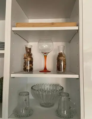 a shelf with glass jars and a wine glass at Élégant et confortable, près de l'aéroport et de la gare in Marrakech