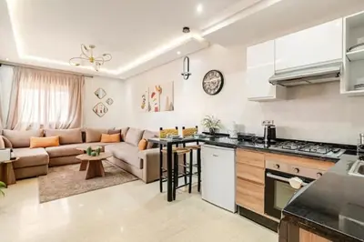 a kitchen and a living room with a couch at Élégant et confortable, près de l'aéroport et de la gare in Marrakech