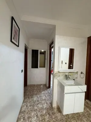 a white bathroom with a sink and a mirror at Appartement cosy avec 2 terrasses in Marrakech