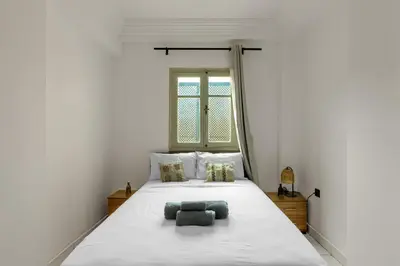 a bedroom with a large white bed with two pillows at Appartement yasmina in Marrakech