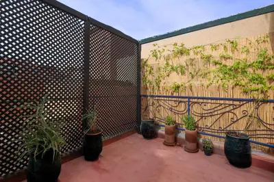 a fence with potted plants on a patio at Appartement yasmina in Marrakech