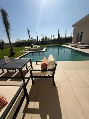 a swimming pool with a table and a bench next to a table and a table at Villa Zeytoune sans vis à vis in Marrakech
