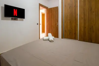 a bed with two pillows and a tv on a wall at Heart of Marrakech - Hivernage 2 bedroom apartment in Marrakech