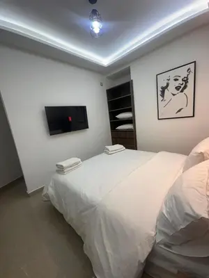 a bedroom with a white bed and a flat screen tv at Central nest romantic stay in Marrakech