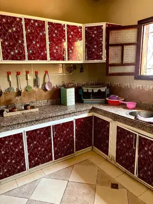 a kitchen with red and white cabinets at luxery in Aït Bou Setta