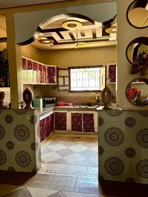 a kitchen with red cabinets and a tile floor at luxery in Aït Bou Setta
