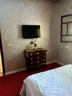 a bedroom with a bed and a tv on a wall at luxery in Aït Bou Setta