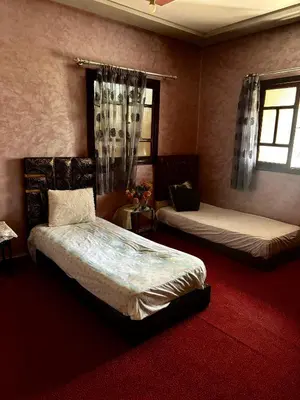 a bedroom with two beds and two windows at luxery in Aït Bou Setta