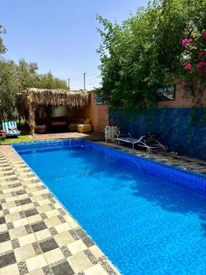 a swimming pool with blue water in a yard at luxery in Aït Bou Setta