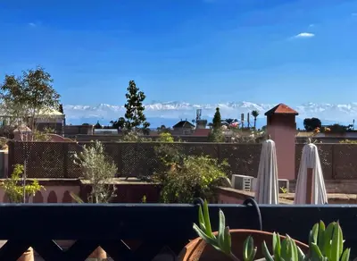 a view of the mountains from a balcony with umbrellas at Riad Madame Riad privé à deux pas de la Place Jemaa El Fna in Marrakech