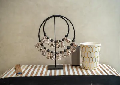 a beaded necklace on a table next to a cup at Riad JAIA in Marrakech
