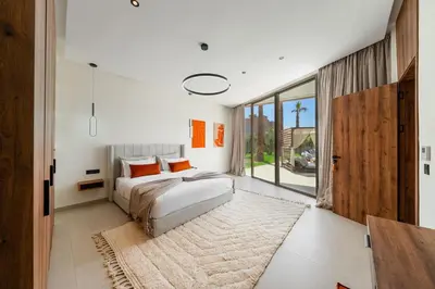 a bedroom with a bed and a large window at Villa Dar Al Jaddah, Luxury and Refinement in Marrakech