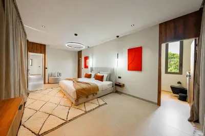 a bedroom with a large bed and a bathroom at Villa Dar Al Jaddah, Luxury and Refinement in Marrakech
