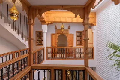 a large hallway with a wooden staircase with wooden railings at Riad Jardin d'Orient in Marrakech