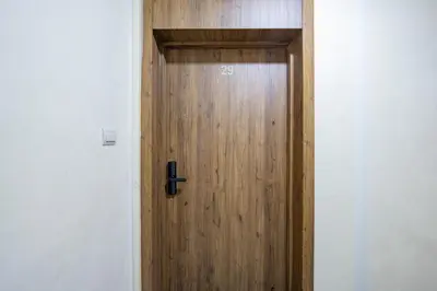 a wooden door in a room with a white wall at Urban Dream piscine et central in Marrakech