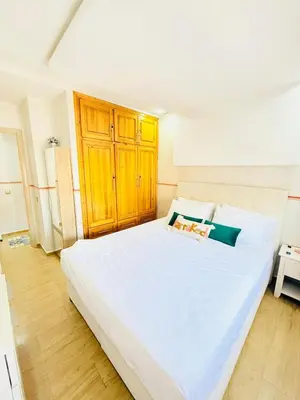 a bedroom with a large white bed with wooden floors at Full Moon Marrakech in Marrakech