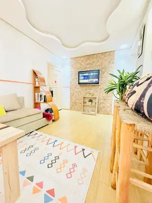 a living room with a couch and a tv at Full Moon Marrakech in Marrakech