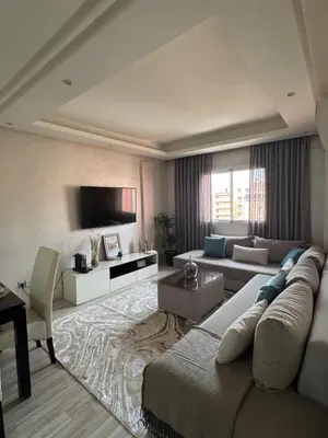 a large living room with a couch and a tv at Appartement moderne proximité Carré Eden Marrakech in Marrakech