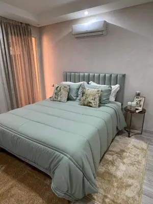 a bedroom with a large bed with two pillows at Appartement moderne proximité Carré Eden Marrakech in Marrakech