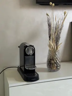 a black heater sitting on top of a table with a vase at Appartement moderne proximité Carré Eden Marrakech in Marrakech