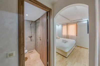a bathroom with a shower and a bed in a room at Marrakech Duplex Spacieux avec Terrasse in Marrakech