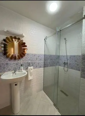 a bathroom with a sink and a shower with a mirror at Appartement refait à neuf in Marrakech