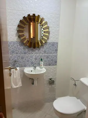 a bathroom with a sink and a toilet and a mirror at Appartement refait à neuf in Marrakech