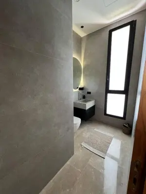 a bathroom with a toilet and a sink and a window at Villa les palmiers in Marrakech