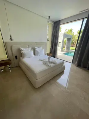 a white bed in a room with a large window at Villa les palmiers in Marrakech