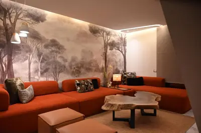 a living room with an orange couch and a painting at Whispers of NATURE in Marrakech