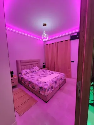 a bedroom with a bed with pink lighting at Modern Apartment with Pools & Free Parking in Marrakech