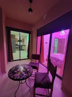 a room with a table and chairs and a bed at Modern Apartment with Pools & Free Parking in Marrakech
