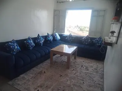 a living room with a blue couch and a coffee table at Menara Airport Appartement - 10 Min Walk in Marrakech